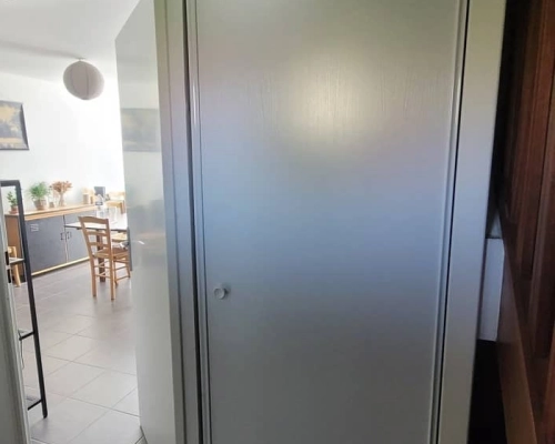 Placard blanc avec porte fermée avant les travaux, vue du couloir, montrant l'entrée du salon